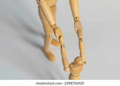 one wooden mannequin helping another as friend in need - Powered by Shutterstock