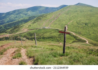 One Wooden Red Signpost In The Summer Mountain With Copyspace. Conceptual Leading Indicator. Old Arrow On The Wooden Signpost Pointing To A Direction.