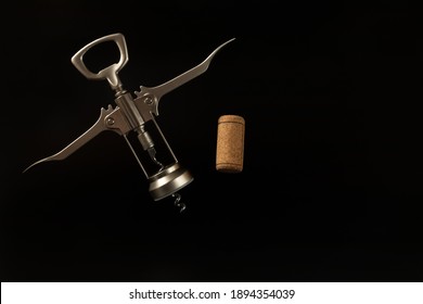 One Wooden Wine Cork And Flying Corkscrew On The Black Background With Copy Space. Wine Concept. Picture For Wine Map.