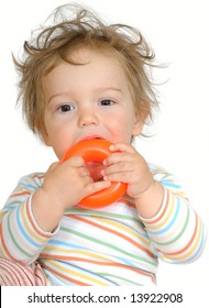 One Year Old Baby With Brown Eyes And Curly Hair Teething On Orange Plastic Ring, Isolated On White