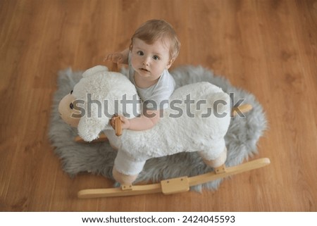 One year old baby with a fluffy white sheep toy