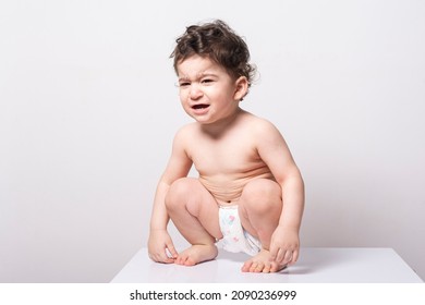 One Year Old Baby Wearing A Diaper And Squatting On A White Table, Crying Expression 