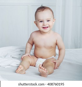 One Year Old Baby Wearing Diapers In Bed At Home