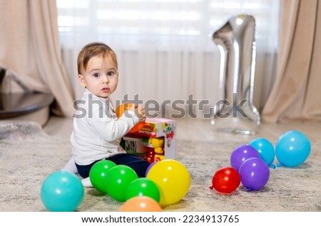One year old with colorful balloons. Kids birthday party. 