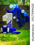 One year party decorations outdoors. Blue and white decor in marine style balloons, small flags, Lifebuoyr, number one for baby boy happy birthday party. Festive decorative elements, photo zone