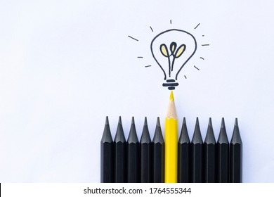 one yellow pencil and light bulb among black ones  business concept