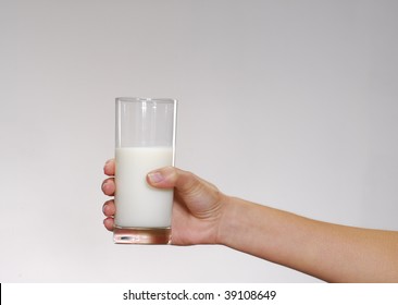 One Youg Female Hand Holding A Glass Of Milk.