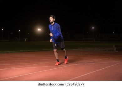 One Young Adult Man, Runner, Running Tracks. Dark Night Time.