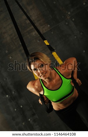 Similar – Side profile view portrait of one young athletic woman at crossfit training, exercising with trx suspension fitness straps over dark background, looking away