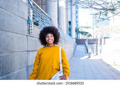 one young and beautiful businesswoman walking after working day in the office. Cheerful African or American girl