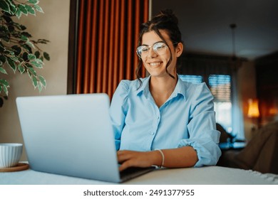 One young beautiful caucasian woman wearing glasses while working from home on her laptop  - Powered by Shutterstock