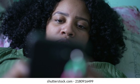 One Young Black Hispanic Woman Closeup Eyes Looking At Phone Screen Lying In Bed