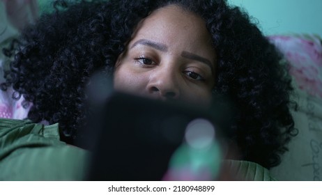 One Young Black Hispanic Woman Closeup Eyes Looking At Phone Screen Lying In Bed