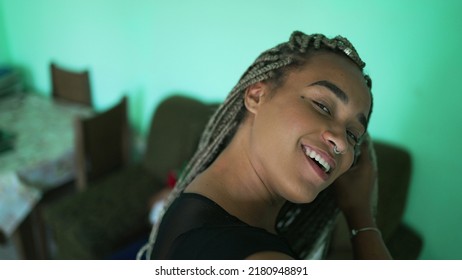 One young black woman playing with braided hair. An African American girl showing her dreadlocks box braid hairstyle