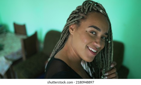 One young black woman playing with braided hair. An African American girl showing her dreadlocks box braid hairstyle