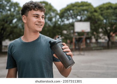 one young caucasian man teenager hold supplement shaker stand outdoor - Powered by Shutterstock