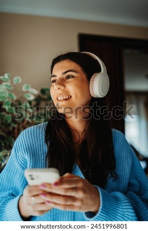 One young caucasian woman is listening to music on wireless headphones 