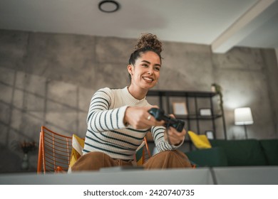 One young caucasian woman play video game console using joystick controller while sitting at home real people leisure concept copy space - Powered by Shutterstock