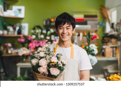 One Young Happy Asian Male Florist Working In Shop