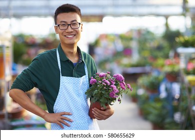 One Young Happy Asian Male Florist Working In Shop