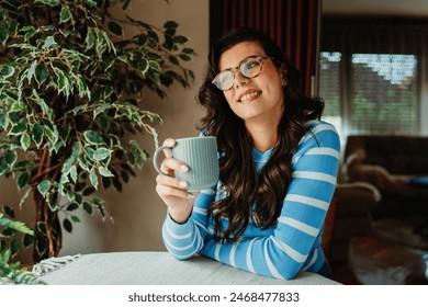 One young and happy woman enjoying morning coffee or tea at her home	 - Powered by Shutterstock