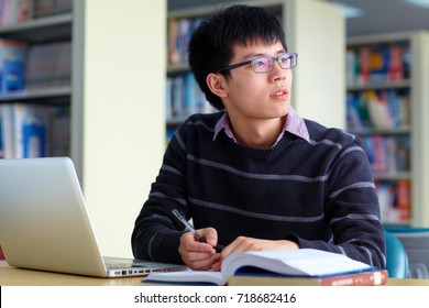 One Young Male Chinese College Student Study In The Library By Computer On The Table