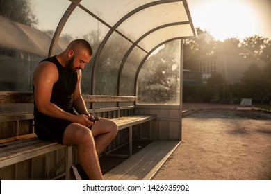 one young man athlete, using his phone, while sitting .