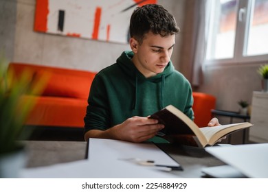 one young man caucasian teenager student learning study reading book while sitting at home prepare exam or work on project real people education concept copy space - Powered by Shutterstock