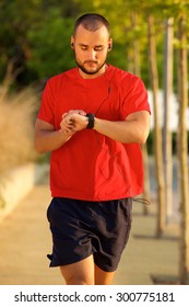 One Young Man Walking And Checking Time On Watch During Workout Exercise