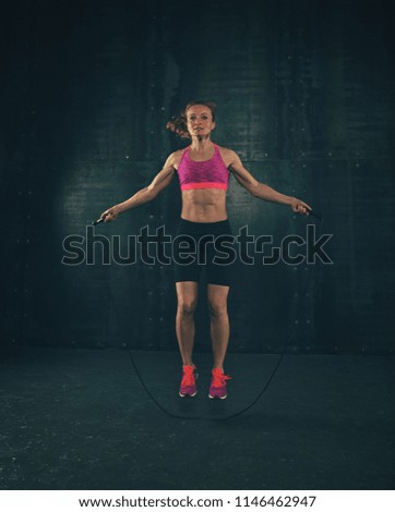 Similar – One young middle age athletic, woman training, exercising with fitness jumping rope over dark background, full length front view, looking at camera