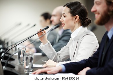 One of young politicians speaking in microphone among other participants of conference - Shutterstock ID 1069150514