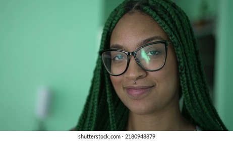One young serious black woman with box braids hairstyle portrait face turning head to camera
