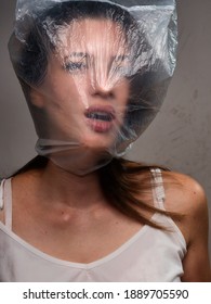 One Young Woman, Chocking On Plastic Bag. Upper Body Shot.