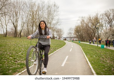 One Young Woman, Riding Bicycle Wheelie Style.