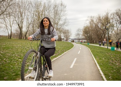 One Young Woman, Riding Bicycle Wheelie Style.