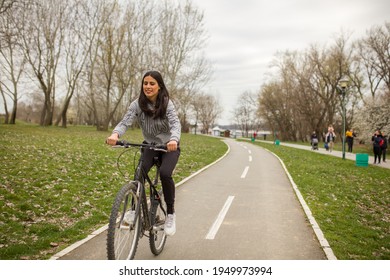 One Young Woman, Riding Bicycle Wheelie Style.