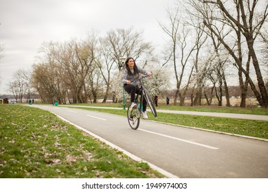 One Young Woman, Riding Bicycle Wheelie Style.