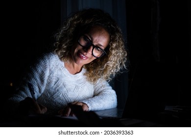 One Young Woman Using Laptop And Working On A Computer At Night At Home. Businesswoman At Job In His Office