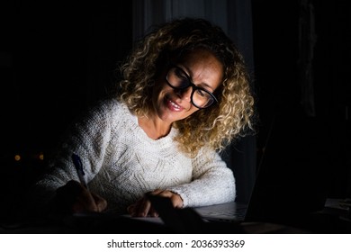 One Young Woman Using Laptop And Working On A Computer At Night At Home. Businesswoman At Job In His Office