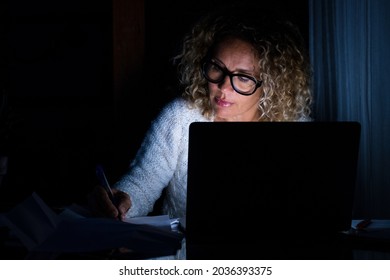 One Young Woman Using Laptop And Working On A Computer At Night At Home. Businesswoman At Job In His Office