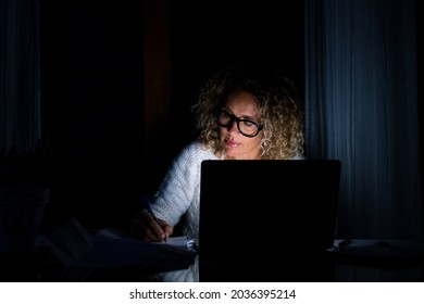 One Young Woman Using Laptop And Working On A Computer At Night At Home. Businesswoman At Job In His Office