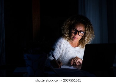 One Young Woman Using Laptop And Working On A Computer At Night At Home. Businesswoman At Job In His Office