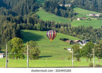 One-man hopper hot-air balloon floating low above the ground in the distance