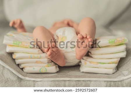 One-month-old baby lying next to a stack of diapers. How to choose the best diapers for your newborn. Baby care, diaper selection, and parenting essentials concept