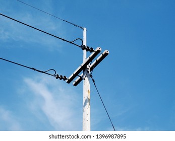 One-phase Electrical Wire On The Pole And Guy Wire Is A Fastening Cable For The Tension Of The Electrical Wire To Balance In The Last Column On A Blue Sky Background.