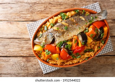 One-pot Thieboudienne Traditional West African Fish And Rice Dish With Vegetables Closeup In The Dish On The Table. Horizontal Top View From Above
