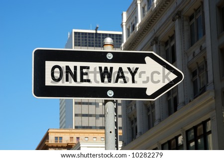 Oneway road city sign on a blue sky and buildings background