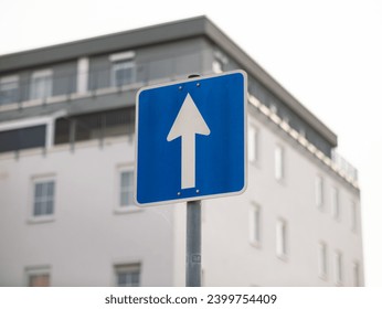 One-way street sign in Germany. The white arrow on the blue square is pointing ahead. The travel direction is straight on. - Powered by Shutterstock
