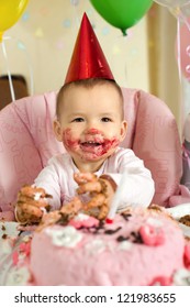 one-year-old little girl with  dirty-faced solemnize birthday, happy laughter, vertical photo