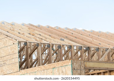 An ongoing construction site in the suburbs, featuring the framing stage of a single-family house.